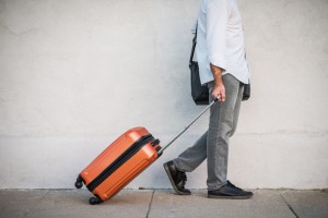Male Traveler Rolling His Suitcase